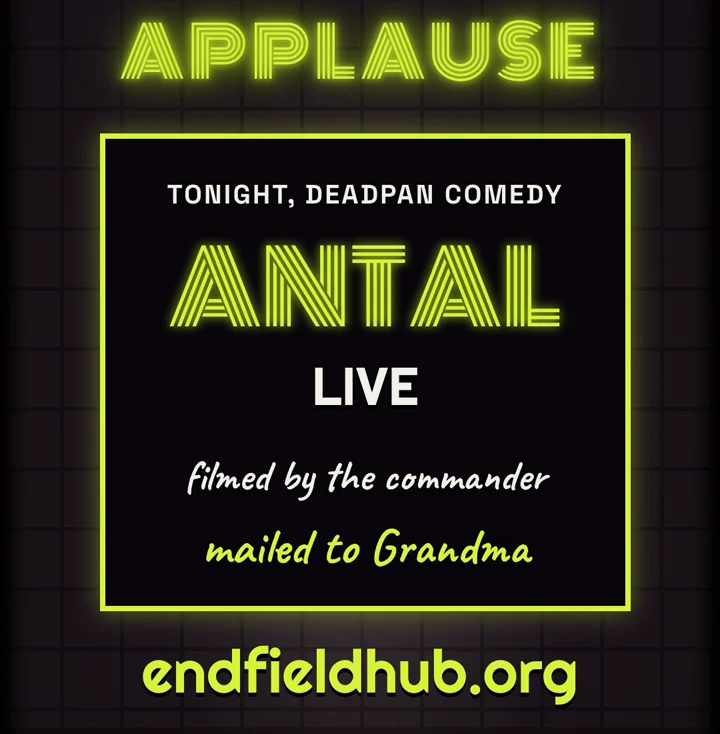 The ANTAL LIVE comedy poster, filmed by the commander and mailed to Grandma, under a lit APPLAUSE sign